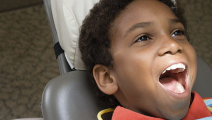 Young boy with mouth open at dentist visit.