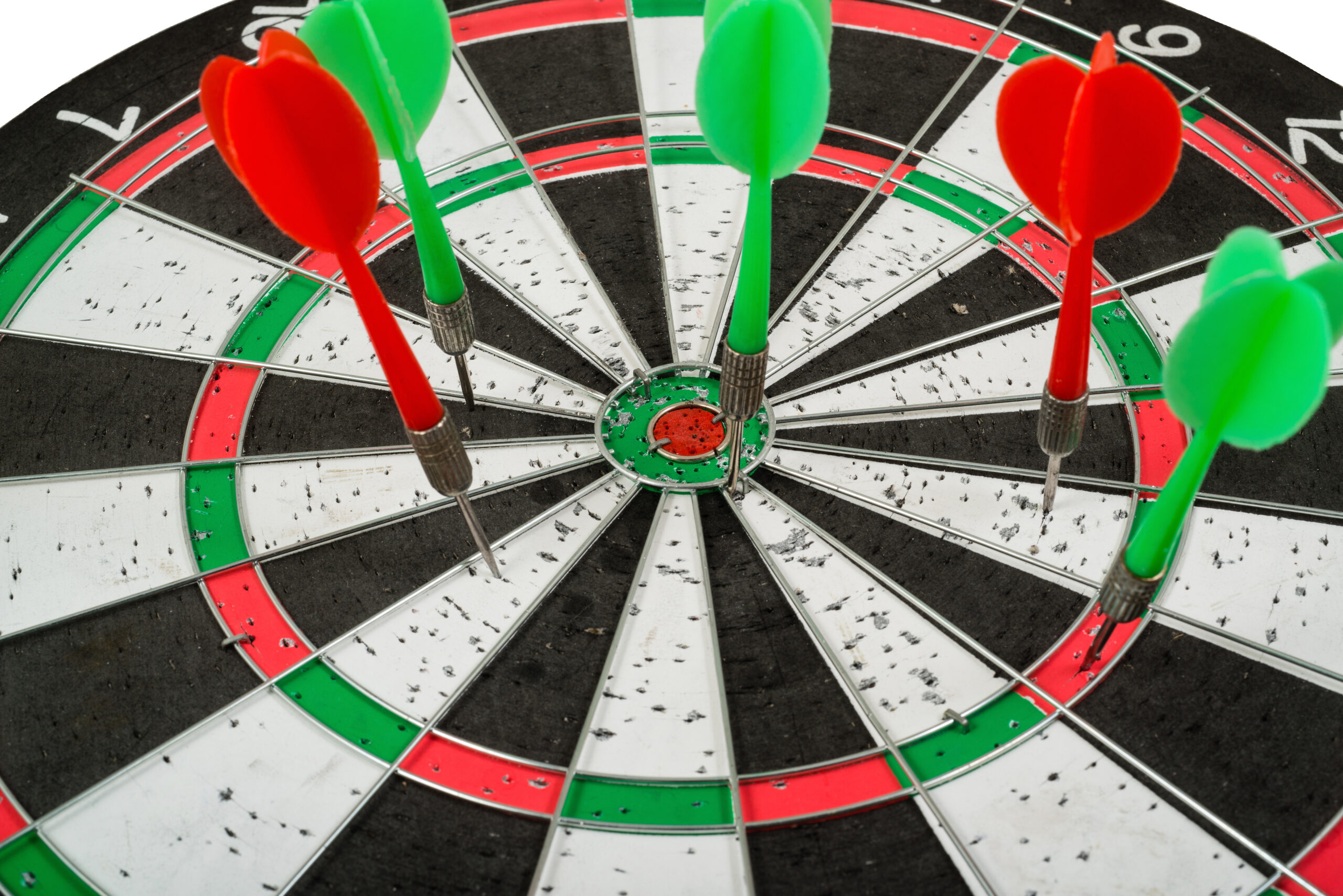 Dartboard with green and red darts on the board.